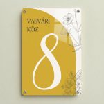 Mustársárga színű modern házszámtábla virágmintával.
